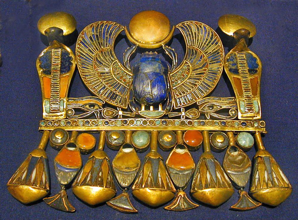 A pectoral neclacel belonging to Tutankhamun, representing his Prenomen. Pectoral scarab found in Tutankhamun's tomb. This would have been worn during life hung from a gold chain on his chest.