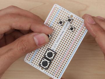 Install tactile buttons Add 6mm buttons to the Perma- Proto by inserting them into place with