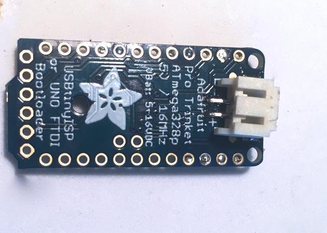 Take some solder and tin the two pads on the back of your Pro Trinket, and carefully solder on a male JST connector. Now you can plug in a battery of your choice.