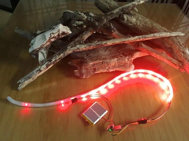 Turn on your LED strand and put your fire on top of it. Weave the strand in and around the logs.