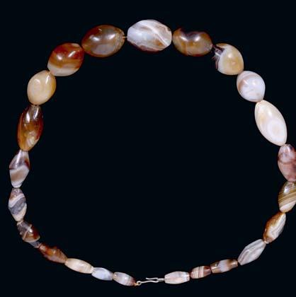 100-150 49 49 AN BABYLONIAN AGATE NECKLACE Circa 1st Millennium B.C. Restrung, several lentoid polished agate beads form this necklace with distinctive banding.