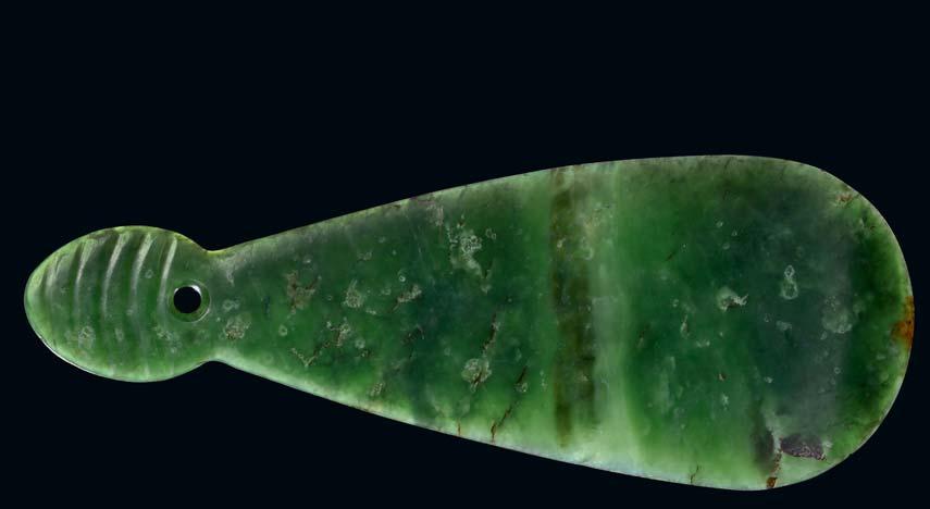 171 171 A MAORI POUNAMU MERE Probably nephrite, with a the broad leaf shaped face that narrows to terminate in a butt incised with five grooves on each side with a small hole through which a fiber