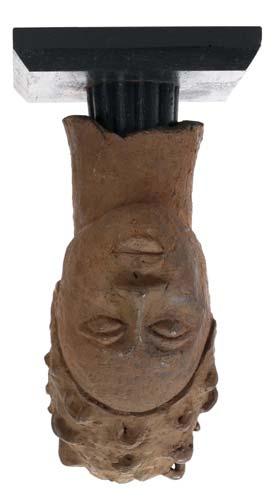 200-400 229 230 AN IFE COMMEMORATIVE FEMALE HEAD, NIGERIA An earthenware female head with smooth modelled facial features and an elaborate hairstyle set back from the forehead made up of several