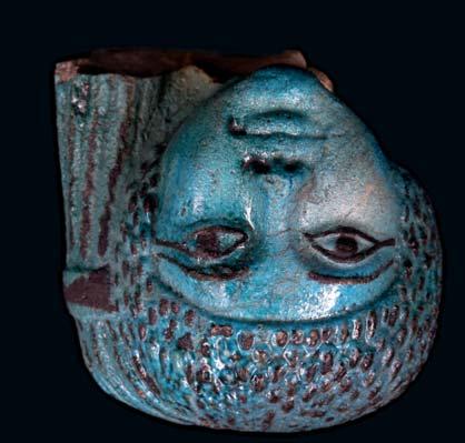 9 AN EGYPTIAN FAIENCE HEAD OF A WOMAN A fragment from a larger figure possibly of a princess, with a side lock falling on the right side of her head, with finely depicted facial features, 8.4cm high.