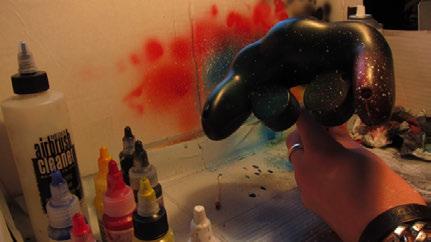 Press the cap of the spray can down half way until you get a sputtering spray that produces large droplets of paint.
