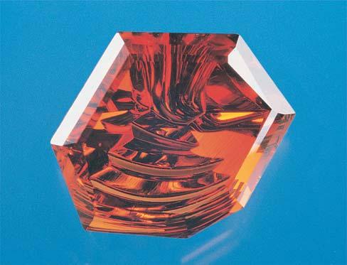 Figure 6. Glenn Lehrer fashioned a 98.51 ct piece of spessartine garnet from Madagascar into this 63.14 ct fantasy cut (left). The curved facets on the pavilion (right) carry the light into the stone.