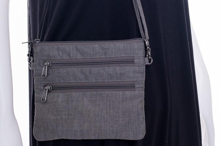 linen, lined with cotton. Features two interior pockets (one zippered), snap button closure. 12.5" x 13.75" x 1.