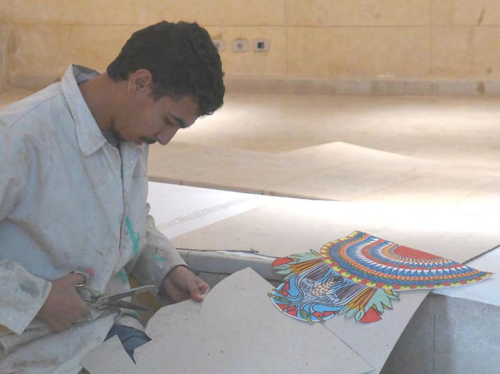Amr s team (Ahmed) preparing one of the painted panels for attachment as part of the wall