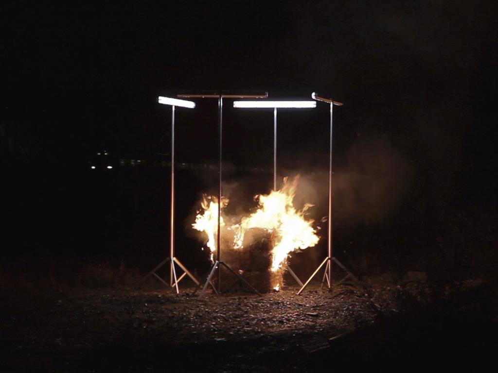The Votive Square Fire (Videostill), 2013 a videoset for a postarchaic custom; aluminium stands
