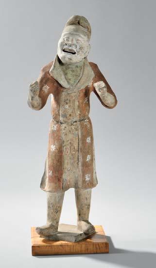 25 24 26 26 Pottery Figure of a Foreign Groom, China, Tang dynasty, figure modeled standing on a square base with arms raised as if to hold reins, the face with Central Asian features, flaring