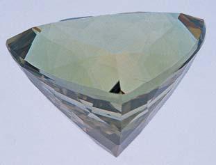 Figure 2. This 16.90 ct triangular cut zoisite has been cleverly faceted so that the three optical directions are parallel to the table and perfectly oriented down the three points.