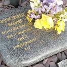 Each surrounded by granite setts and marked with a dedication plaque.