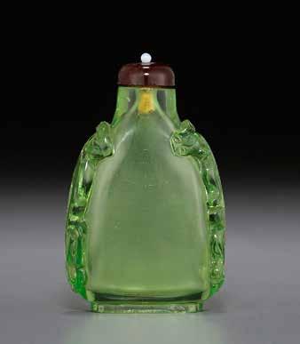 6026 6027 6026 A TRANSPARENT GREEN GLASS 1750-1820 The heavy, tapering form bottle supported on a neatly finished oval foot ring, the narrow sides carved with two raised chilong, the glass of an