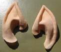 The ears are glued to the skin. Various kinds of glue are used.