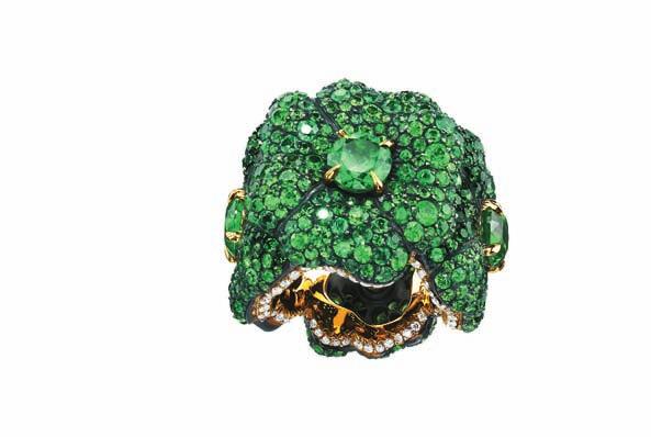 It has a circle of four-leaf clovers, and is composed of rare grass green demantoid garnets; the pavé set leaves with single centre stones, have their flowing edges