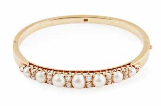 double shank, stamped 14k Ring size: I/J 500-700 63 An early 20th century pearl and diamond set bangle of hinged design, the centre front set with seven half pearls, with