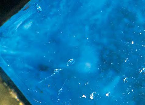 Figure 6. This piece of fashioned blue glass in the Reliquary cross showed the air bubbles typical of glass. Magnified 40. Optical Microscopy.