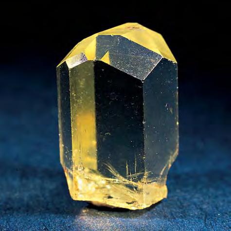 Figure 9. The topaz at Klein Spitzkoppe may be pale yellow as well as pale blue or colorless. This 1.4 cm high yellow topaz crystal has a complex termination. Photo Bruce Cairncross.