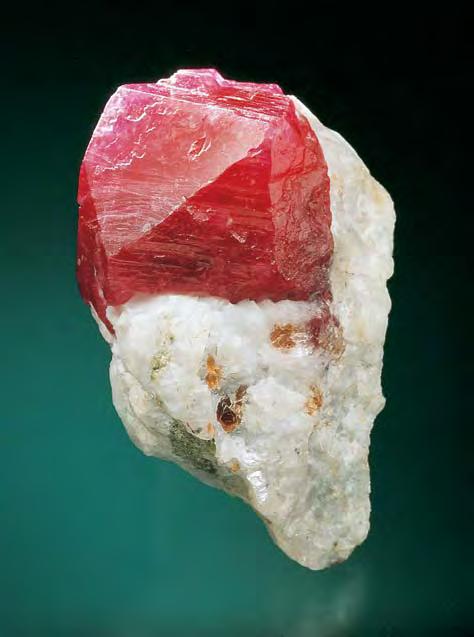 Figure 3. This specimen (4.6 cm high) from Jegdalek, Afghanistan, shows a ruby embedded in calcite marble, along with traces of associated minerals. Courtesy of H. Obodda; photo Jeffrey Scovil. 1994).