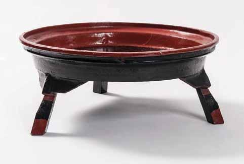 191 RARE BURMESE RED AND BLACK FOOTED TRAY Lacquer, wood and bamboo. Burma, early 20 th Of round shape and raised on three feet, decorated with a simple composition of red and black lacquer.