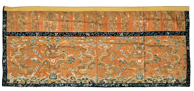 138 Embroidered Hanging Valance, China, 19th century, red silk with a green silk macramé tassel trim, depicting a court official at the center of a performance, surrounded by