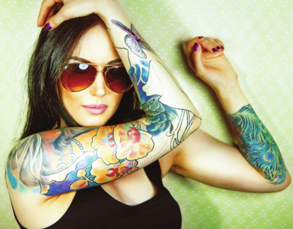 3 [The illustration shows a young woman. She is wearing dark glasses and holding up her bare arms which are covered with tattoos of flowers and butterflies.