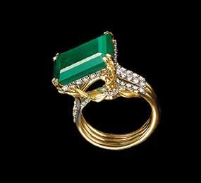 masterpiece. The form of ballet dancers sculpted on either side of the ring hold the massive emerald.