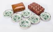 134. Two early 20th century leather cigarette boxes, together with a set of six Meissen style
