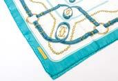 159. A modern Must De Cartier silk scarf, in turquoise, blue, white and gold, sold with an orange Hermes box