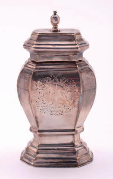 An early 18th century Britannia silver tea caddy, crested, of shaped baluster form with canted corners, the