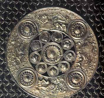 studs. The maximum number of boss studs I am aware of is depicted on a helmet plate from Vendel 14 where a warrior holds a shield with a central boss, which has five securing studs.