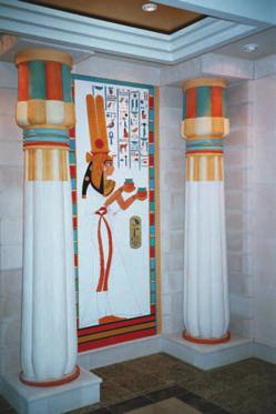 The entrance is marked by an obelisk and six pharaonic statues (with blue beards), painted columns and various tomb depictions