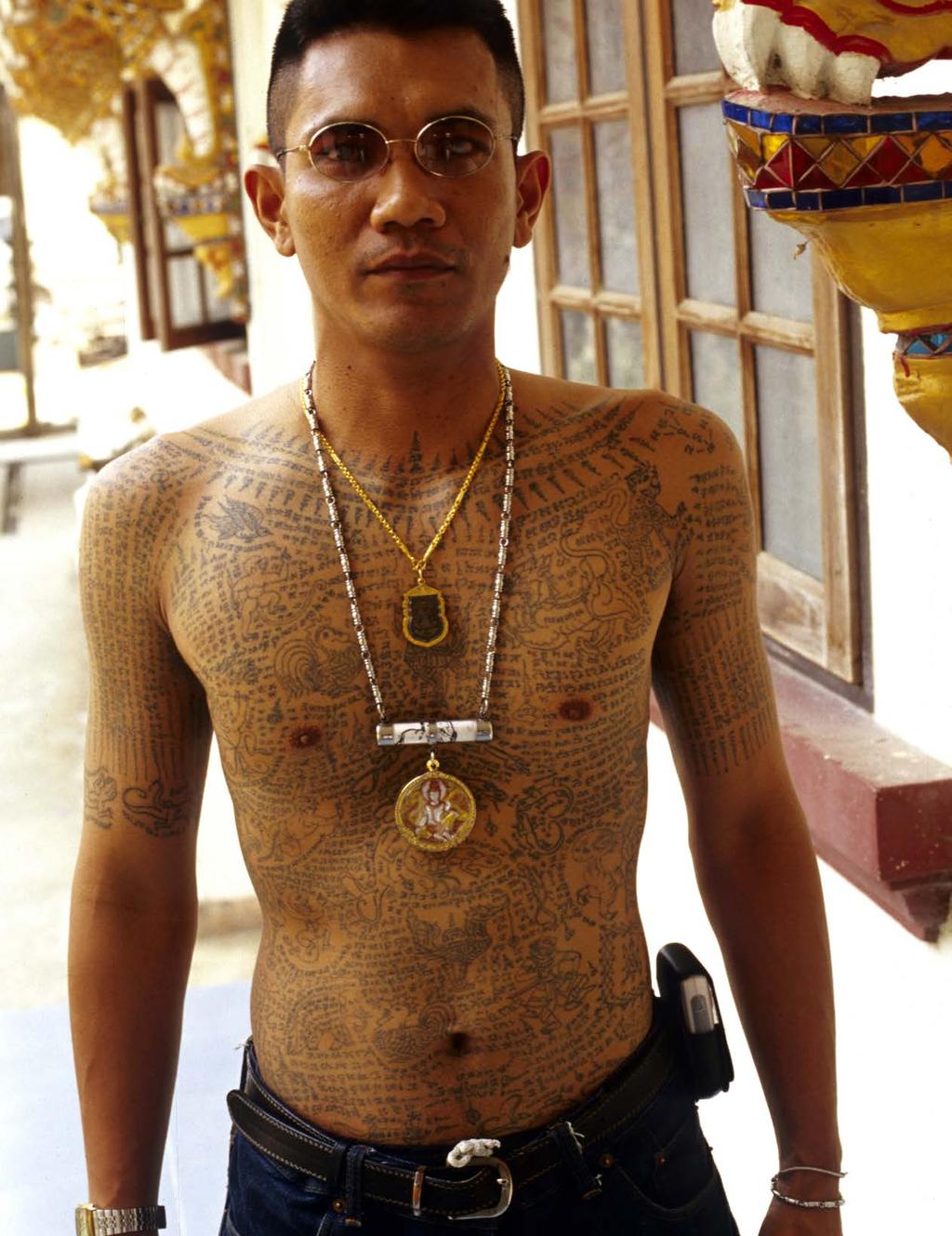 Heavily tattooed disciple visiting Wat Bang Phra monastery. His amulets provide another layer of bodily protection.
