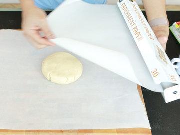 Roll out the dough in between two sheets of parchment paper.