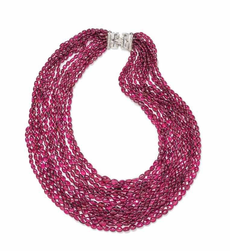 236 237 236 an 18 Karat White Gold, diamond and Graduated multistrand Pink tourmaline Bead necklace, consisting of 12 strands containing numerous tumbled oval pink tourmaline beads measuring