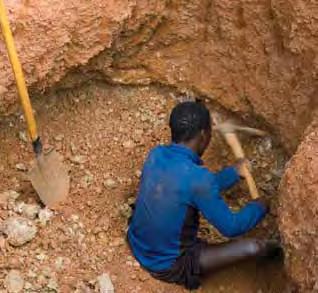 Figure 12. When they reach the tourmaline-bearing layer, the miners search for the gems by digging through the gravels with a pick. Photo by B. M. Laurs.