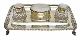 A pair of faceted glass scent bottles, with stoppers, with a Victorian silver twin compartment stand, embossed with shaped oval panels, depicting cherubs faces, raised on four feet, by William