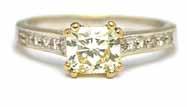 A gold and diamond solitaire ring, collet set with the principal cushion shaped diamond between diamond set V shaped shoulders, ring size N, the principal diamond weighs approx 4.