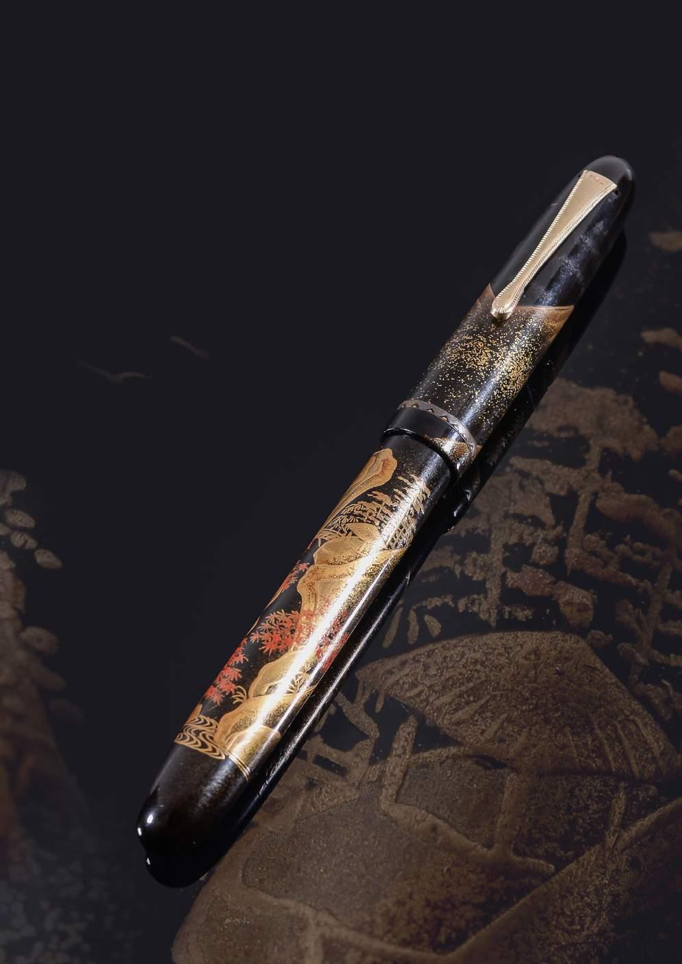 Pens 107 Platinum, Autumn, a maki-e fountain pen by Rosui, circa 1930, the black lacquer cap and barrel with togidashi and takamaki-e autumnal landscape, the nib
