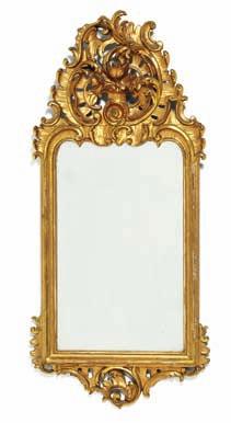 190 a north German rococo giltwood mirror with openwork c-scrolls and rocaille carvings. Mid 18th century. H. 82 cm. W. 37 cm.