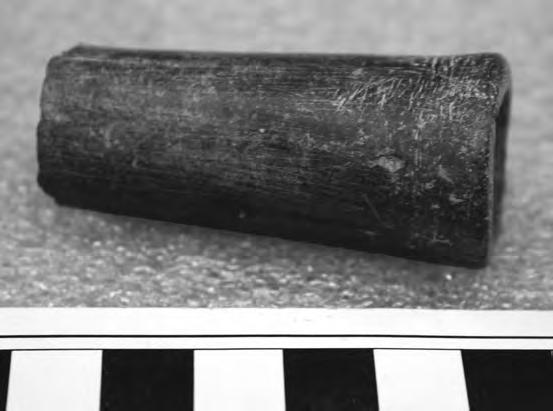 Created of dark gray steatite/serpentine, the pipe had been smoothed over all its outer surfaces, but it shows subsequent scraping that does not appear as an effort at decoration.