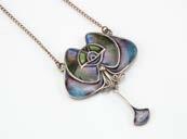 An Art Nouveau style white metal and enamel pendant, having pierced lily of the valley and a