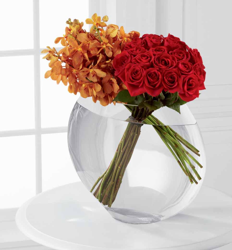 the ftd luxury collection Captivate with this sculptural glass vase, filled with exquisite Mokara orchids and brilliant red Freedom roses.