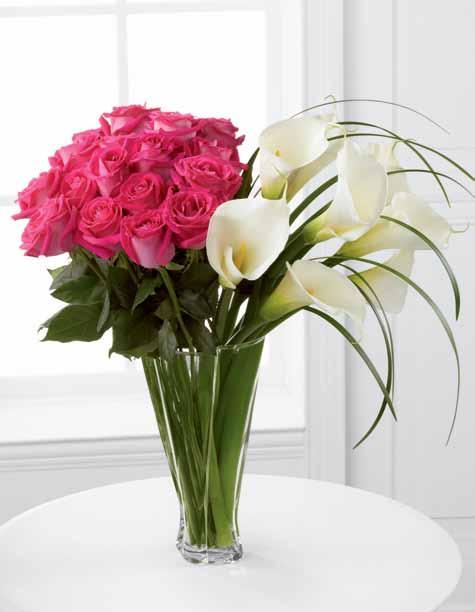 99 LX115 A stunning contrast of hot pink roses and soft white calla lilies captures the imagination. This distinctive design is set in a dynamic vase, skillfully crafted with a gentle twist.