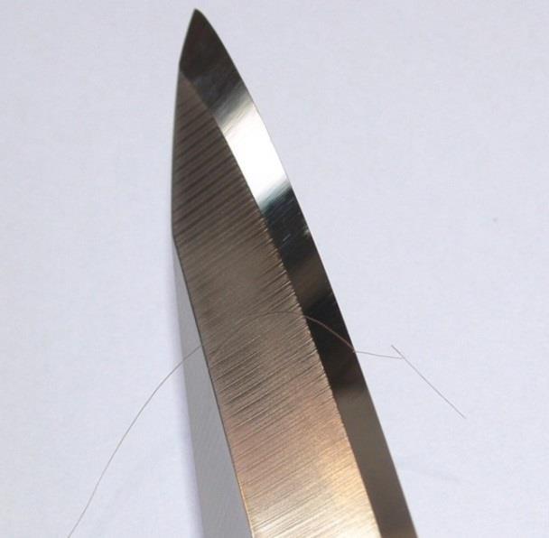 Split hair - the edge catches the hair between cuticles and splits it lengthwise. 60 on BESS scale is where the edge starts splitting a hair; the edge apex width is near 0.1 micron.