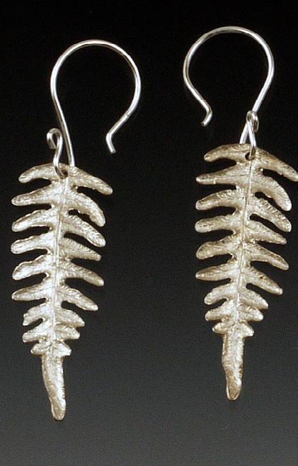 They are accented with two tones of fiery orange and red Swarovski crystals and are suspended from gold ear wires. This style features the petite bracken fern in sterling silver.