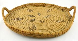 $125 - $175 557 Salish woven rectangular shaped two handled tray, 18 1/2". 558 Salish woven circular two handled basket, 16". Two small Nuu-chah-nulth woven baskets.