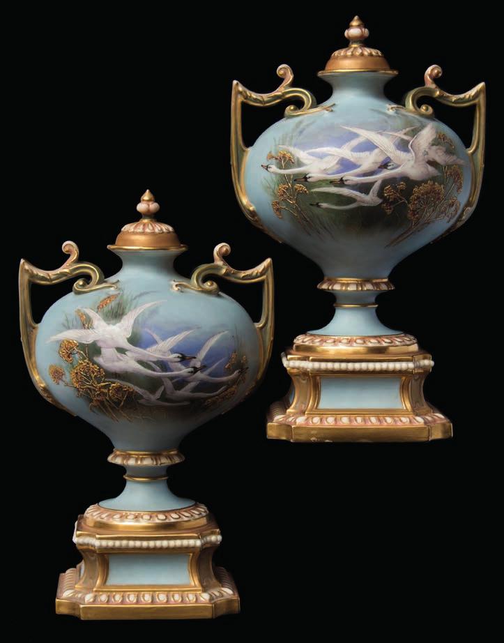 120 621 A pair of Royal Worcester two-handled vases and covers painted by Charles Baldwyn each with swans in flight against a water landscape with reeds and rushes, the