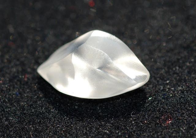 The uncut semi-clear pebble-sized stone is about width of a dainty pinky finger.