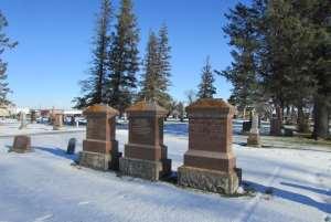 Solid family monuments mark graves of early pioneer families An imposing red granite pillar